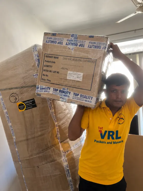 Crew member carrying a packed carton on the shoulder